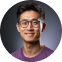 A man wearing glasses and a purple shirt.